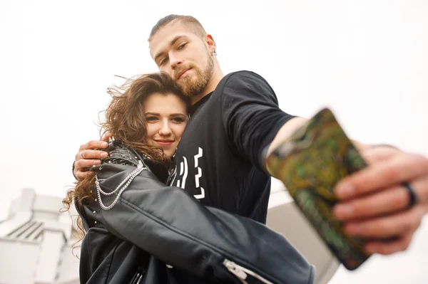 Unga och lyckliga par att ha roligt i staden är fotograferad på en smartphone — Stockfoto