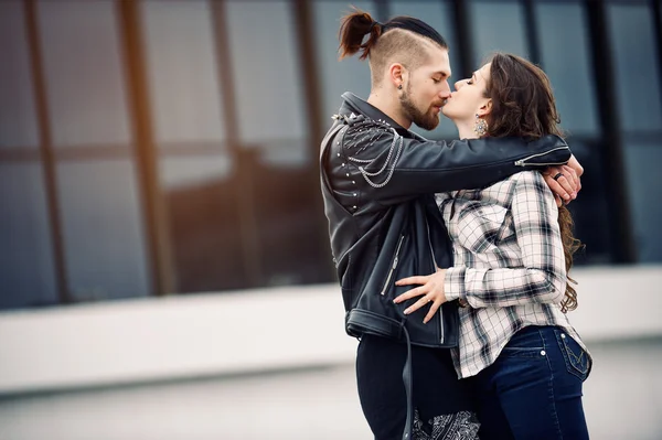 Unga och lyckliga par avkopplande i staden och kyss — Stockfoto