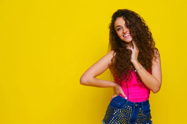 Jeune et belle fille bouclée dans une chemise rose et short bleu o — Photo