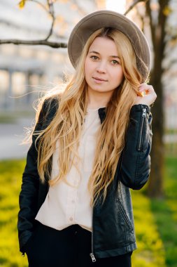 Gün batımında şehirde yürüyüş şapkalı güzel kız