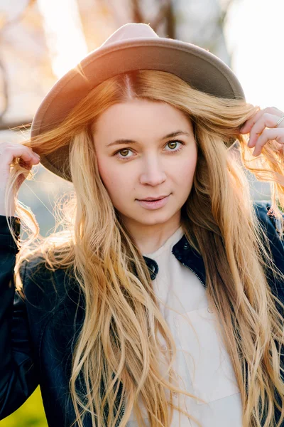 Портрет красивой и молодой девушки в модной шляпе на закате летом — стоковое фото