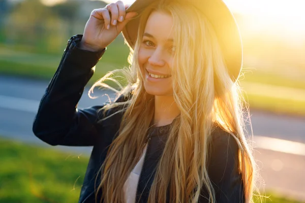 Vacker flicka i en hatt promenader i sommaren på en solig dag och leende — Stockfoto