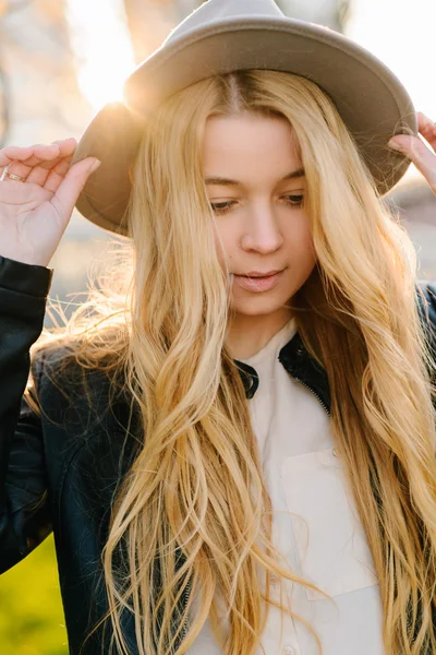 Gün batımında şehirde yürüyüş şapkalı güzel kız