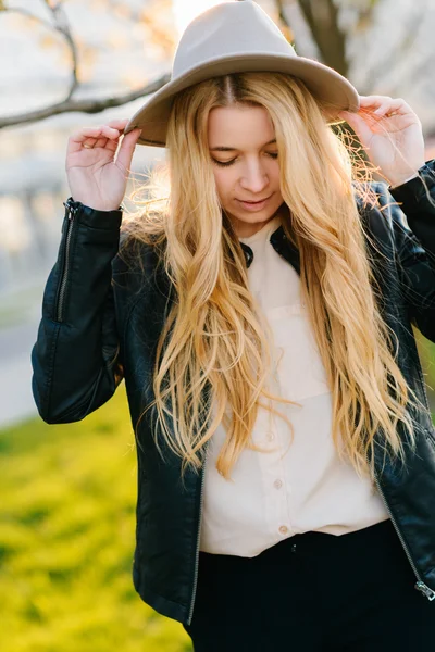 Gün batımında şehirde yürüyüş şapkalı güzel kız