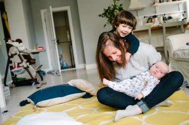 Genç ve mutlu anne evi katında onun küçük çocuklarla oynarken. Çocuk gülmek. Aile kavramı