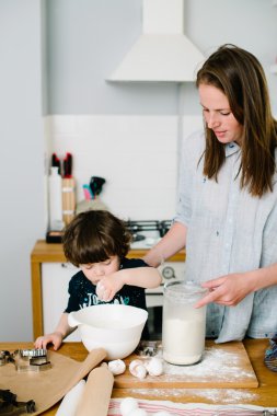 Küçük çocuk annesi kurabiye pişirmek yardım