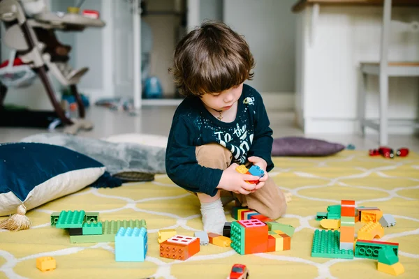 Niño jugando en el constructor en el suelo de la casa . — Foto de Stock