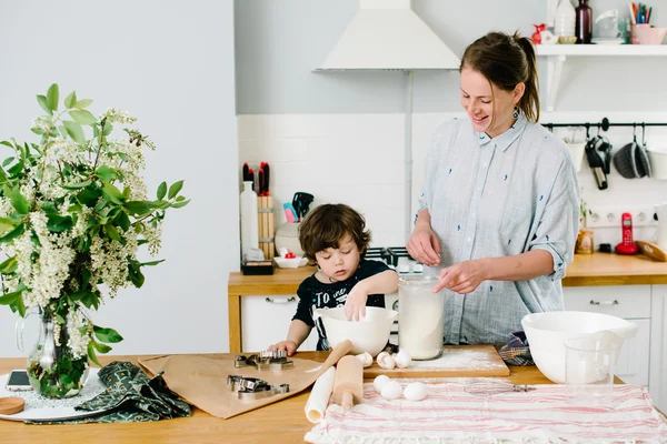 Kleiner Junge hilft ihrer Mutter beim Plätzchenbacken — Stockfoto