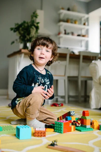 Niño jugando en el constructor en el suelo de la casa . — Foto de Stock