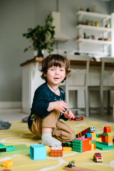 Niño jugando en el constructor en el suelo de la casa . — Foto de Stock