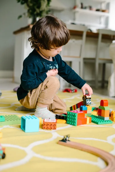Niño jugando en el constructor en el suelo de la casa . — Foto de Stock