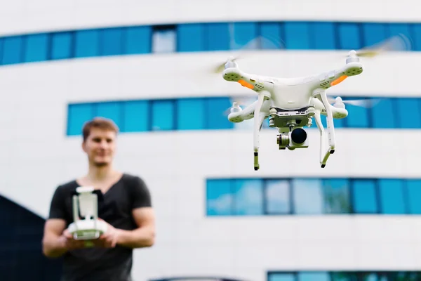 Adam şehrin dron kontrol eder.