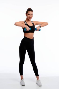 Beyaz arka planda izole halter kullanarak fiziksel egzersiz yapan çekici beyaz tenli kadın.