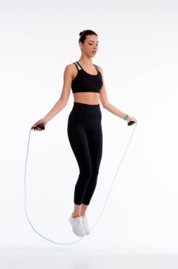 Spotswoman beyaz arka planda ip ile atlıyor. Spor yapan kadın fiziksel egzersiz yapıyor. Sağlık ve kilo verme kavramı