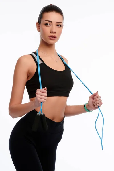 Boynuna ip bağlayıp beyaz izole arka plana atlayan güzel bir sporcu kadın..