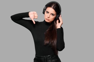 Kablosuz kulaklıklı bir kadın baş parmak hareketi yapıyor, kız müzik dinliyor, izole edilmiş bir geçmişi var.