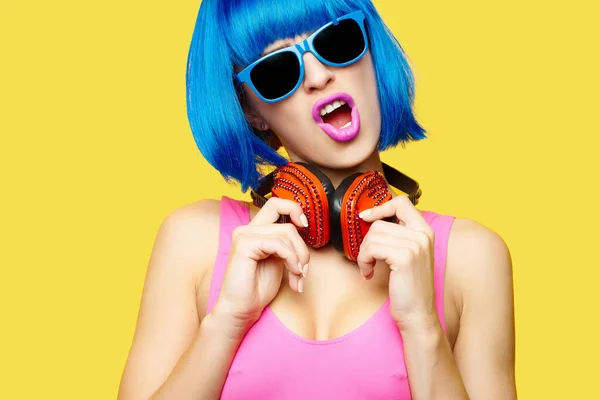 가발에 선글라스를 노란색 배경에 헤드폰을 분홍색 수영복을 소녀가 음악을 고품질 — 스톡 사진