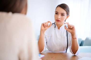 Kadın doktor farklı haplar alıyor ve hastayla içeride tartışıyor.