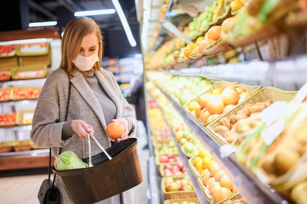 Woman in medical masks is shopping in grocery store during virus pandemic