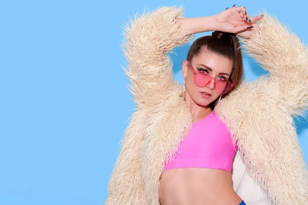 Hipster Mädchen Mit Pelzmantel Und Trendiger Sonnenbrille Auf Hellblauem Hintergrund — Stockfoto