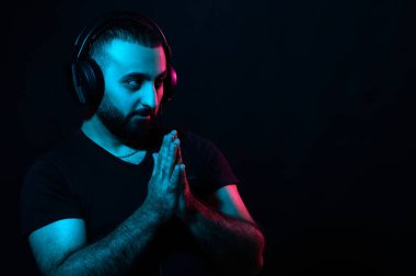 Genç sakallı Arap DJ müzisyen. Kulaklıklı, siyah izole edilmiş arka planda müzik dinliyor. Uluslararası DJ Günü
