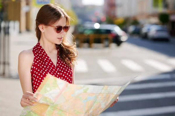 Mujer caucásica viajero en gafas de sol utiliza mapa de papel en la ciudad de verano al aire libre — Foto de Stock