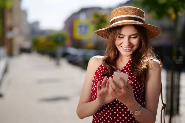 Dışarıda cep telefonu kullanan mutlu, genç bir kadın. — Stok fotoğraf
