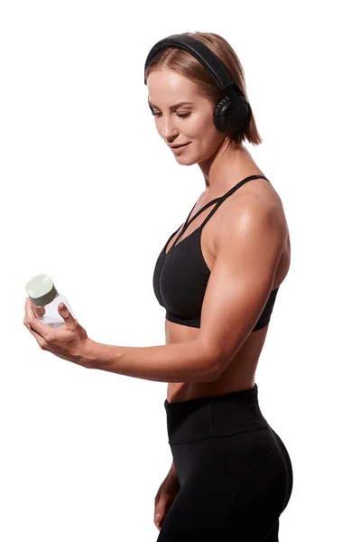 Štíhlá atraktivní žena ve sportovním oblečení s ručníkem pít vodu po cvičení na bílém izolovaném pozadí — Stock fotografie
