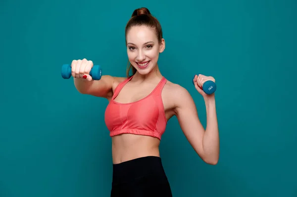Sportos nő visel fitnessz ruhát gyakorló súlyzó beltéri — Stock Fotó