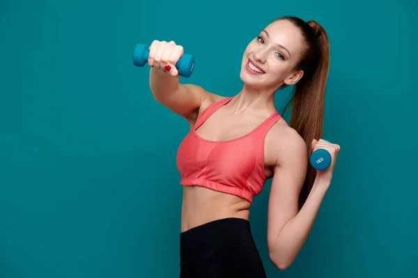 Mujer atlética usando ropa de fitness haciendo ejercicio con mancuerna interior — Foto de Stock