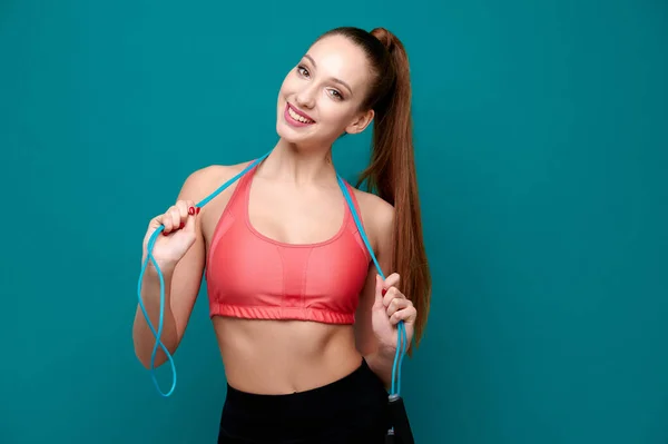 Vonzó fiatal női fitness edző sportruházat ugrókötél zöld elszigetelt háttér — Stock Fotó
