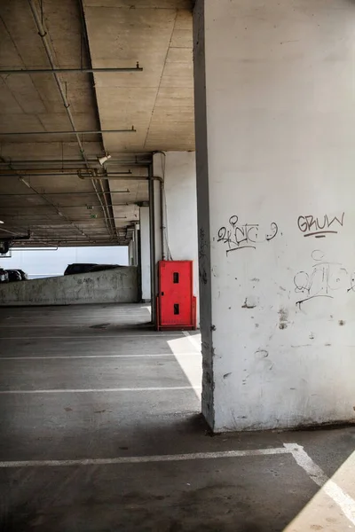 建物の下の駐車場 地下駐車場 コンクリートの柱 赤火安全キャビネット — ストック写真