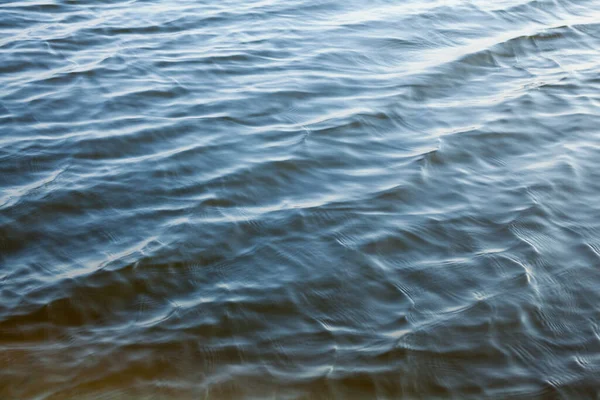 Blue water surface with ripples. Water background. Waves on the water.