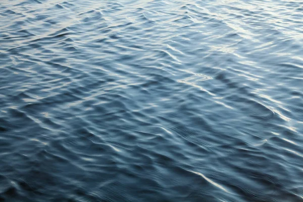 Blue water surface with ripples. Water background. Waves on the water.