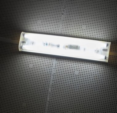 Tavandaki lamba karanlıkta parlıyor. Elektrik ışığı.