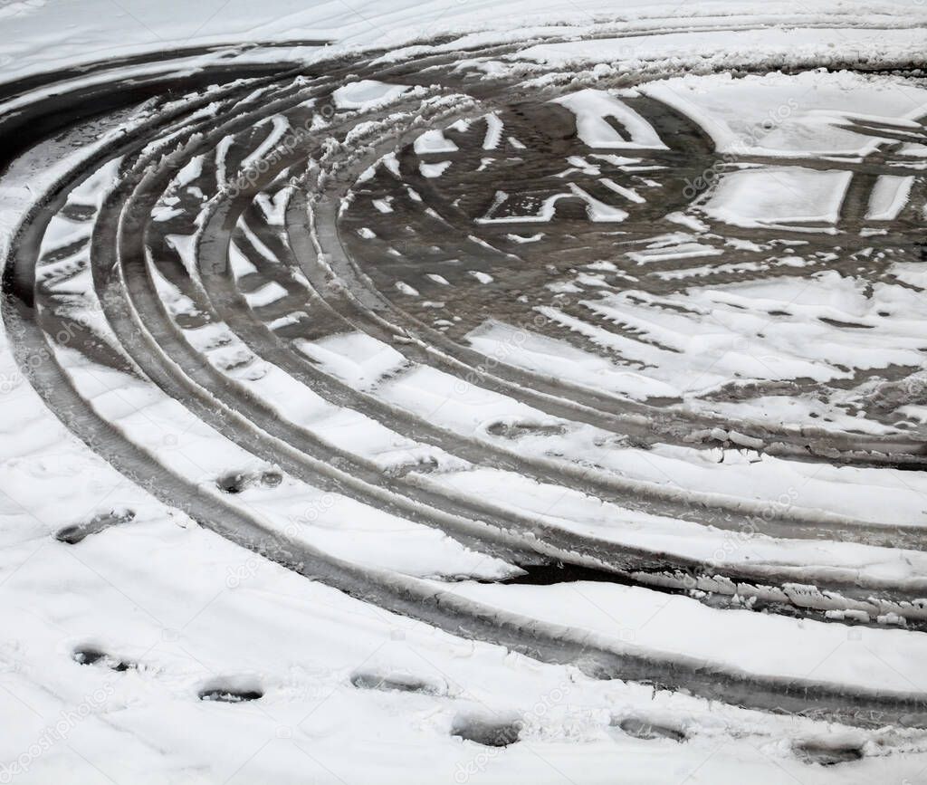Wheel tracks on the winter road covered with snow. Wet melting snow. Thaw.