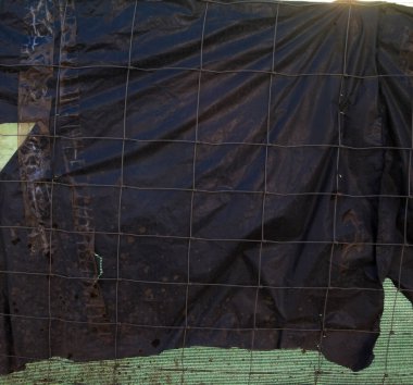 Metal tel çit ve siyah ve yeşil sentetik kumaş.. 