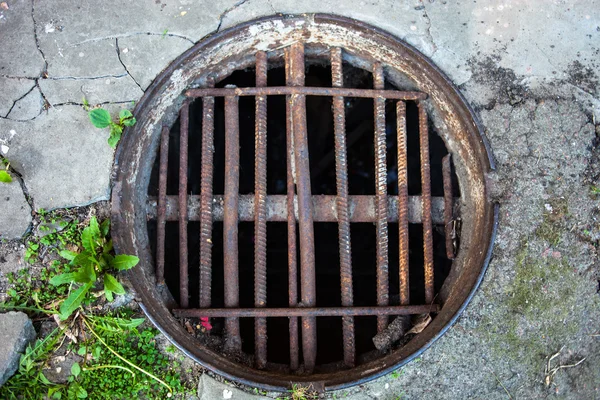 Manhole med handgjorda metall pilbåge täcka — Stockfoto