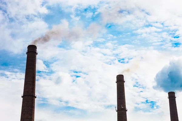 Three smoke stacks of the industrial plant against the cloudy sk — Stock Photo, Image