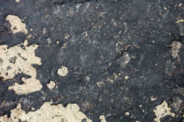 Beton yüzey kısmen siyah katranla kaplı.