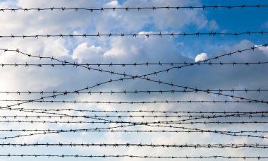 Bulutlu gökyüzü arkaplanına dikenli tel