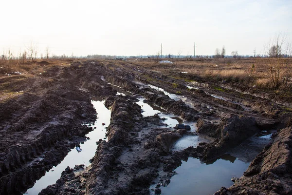 Toprak yolda çamur ve su birikintileri