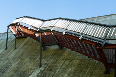 Gri beton duvardaki metal merdivenler.