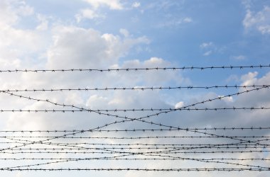 Bulutlu gökyüzü arkaplanına dikenli tel