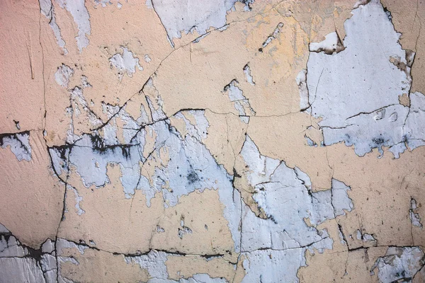 Cracked concrete surface with the remains of sandy-tan paint — Stock Photo, Image