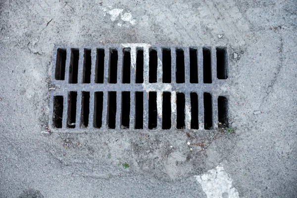 Drain grate with road marking line on it — Stock Photo, Image