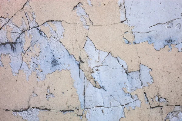 Cracked concrete surface with the remains of sandy-tan paint — Stock Photo, Image