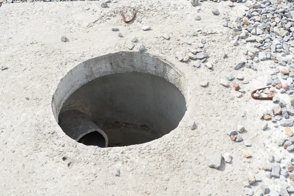 Trou d'homme sans couvercle dans un nouveau bloc de béton — Photo