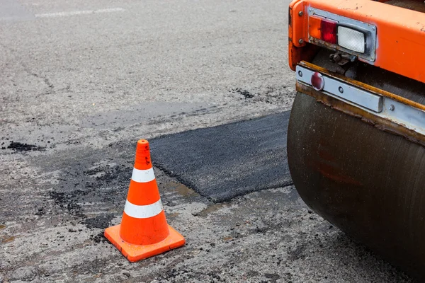 Rouleau routier et cône de circulation sur la construction de la route — Photo