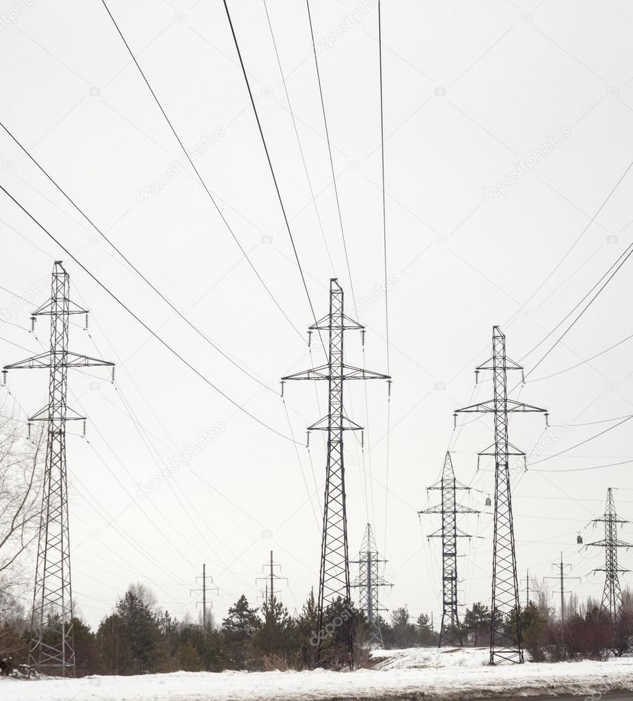 Electricity pylons and power lines in the winter day